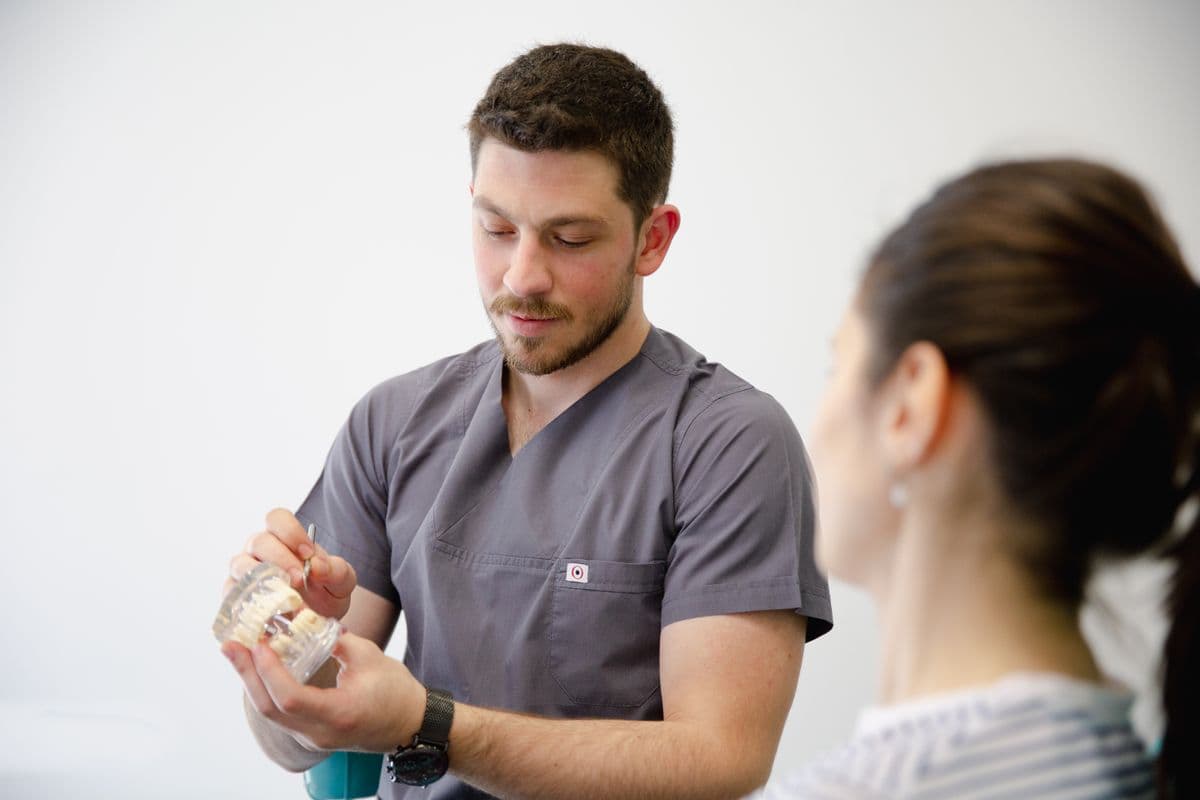 An orthodontist showing a patient a dental model during a consultation