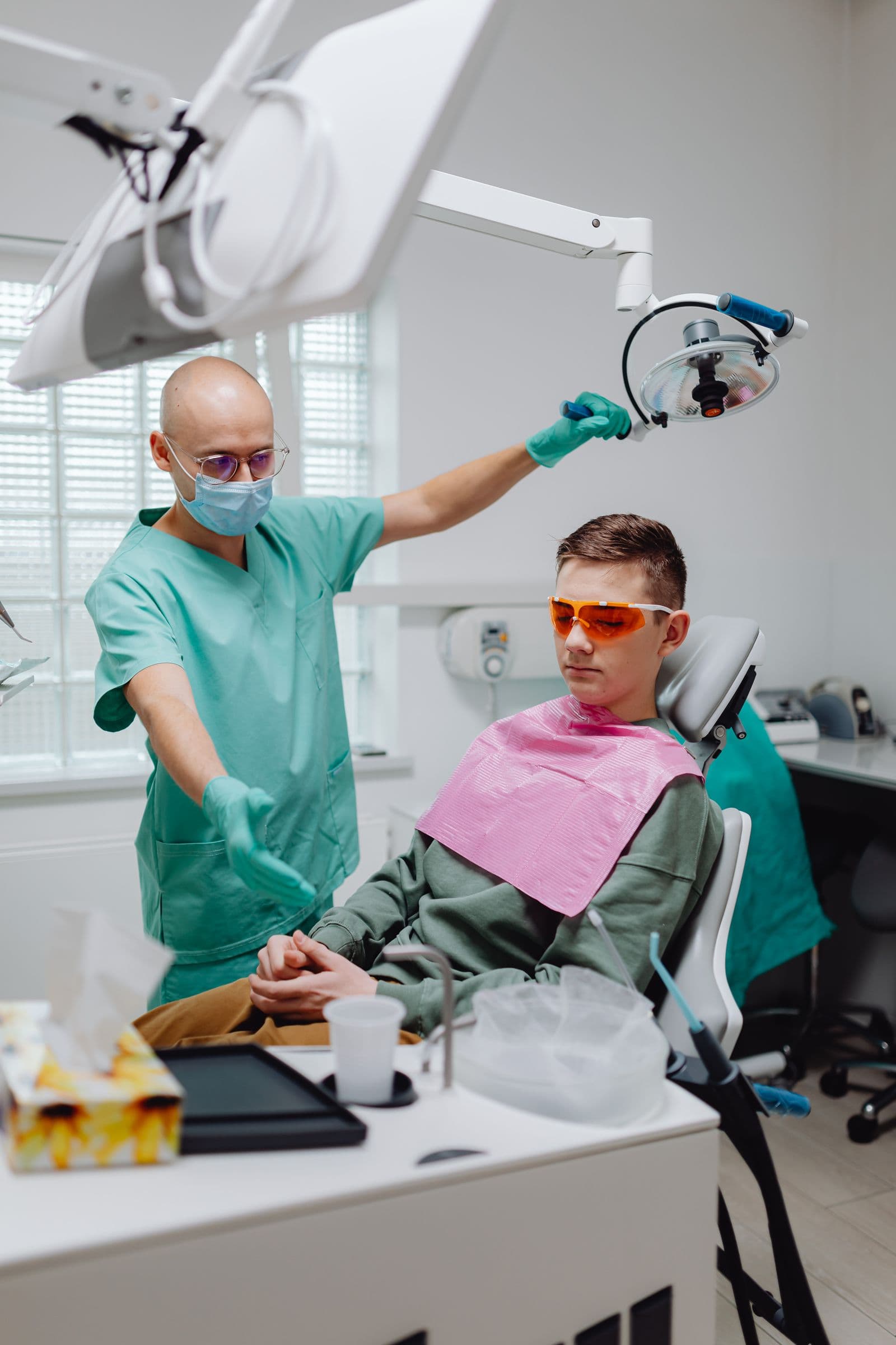 A dental team member giving a thumbs up with a smiling young patient