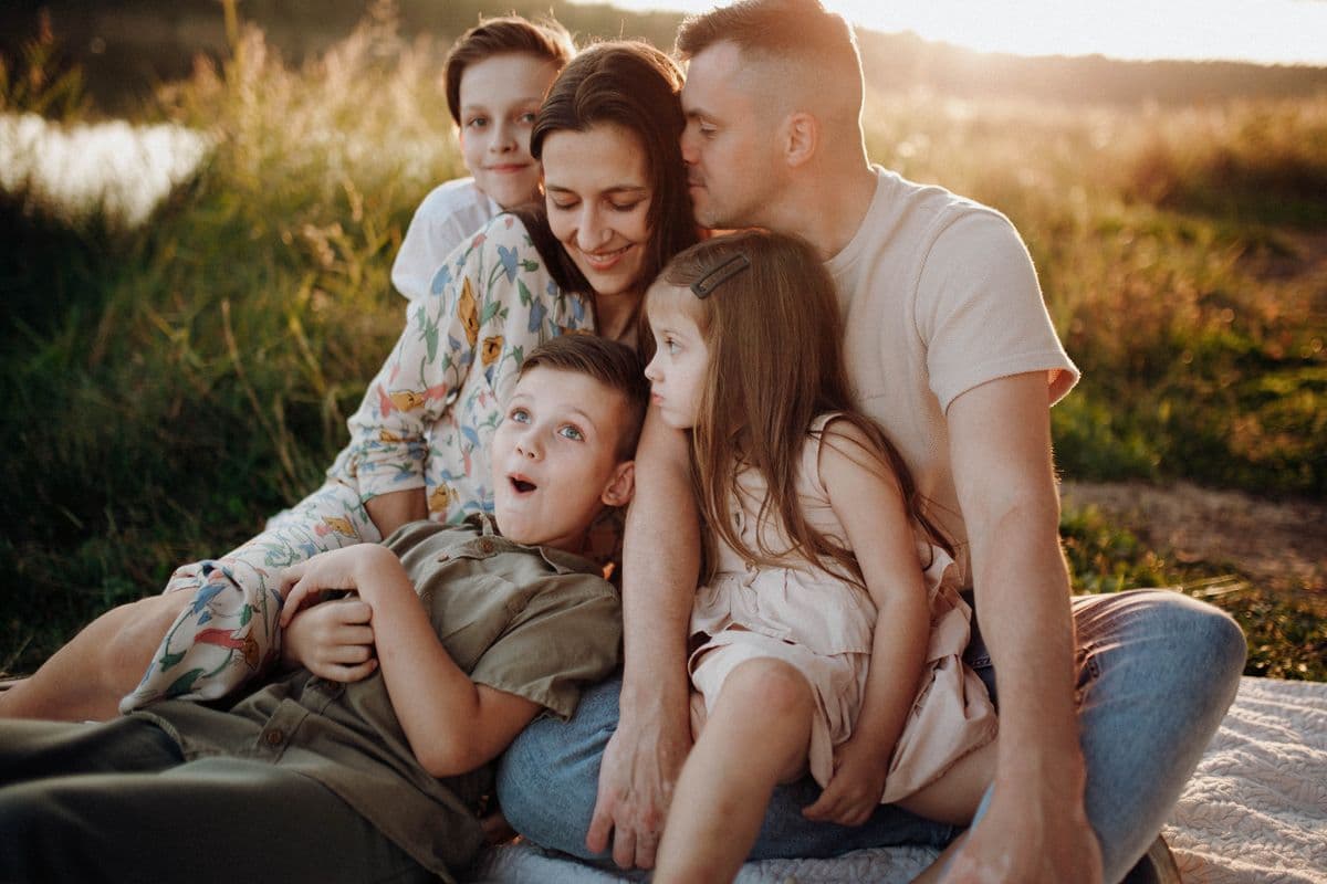 A family smiling together outdoors at golden hour