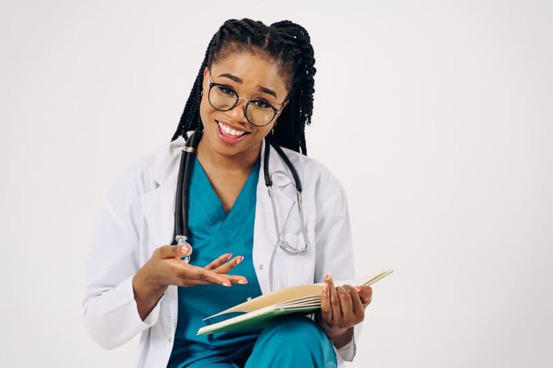Portrait of Dr. Elena Ruiz, DDS, MS, a smiling female orthodontist in a white coat